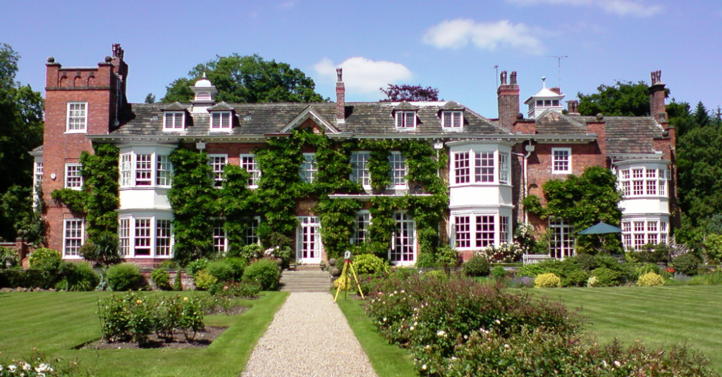 Photograph of an old country house, covered in ivy