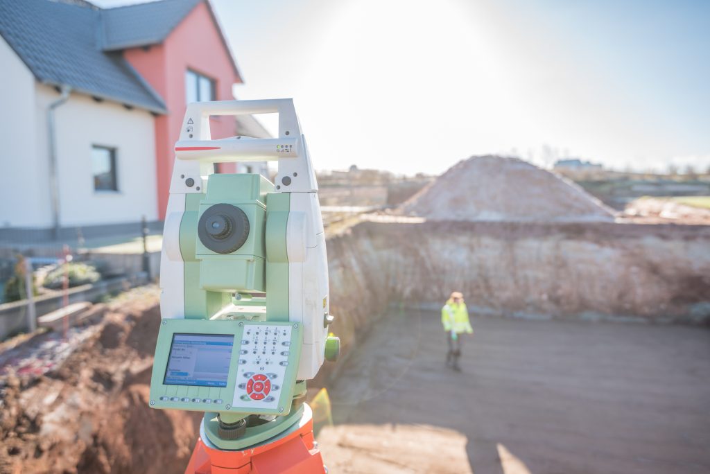 a total station overlooking part of a construction site, with a large hole